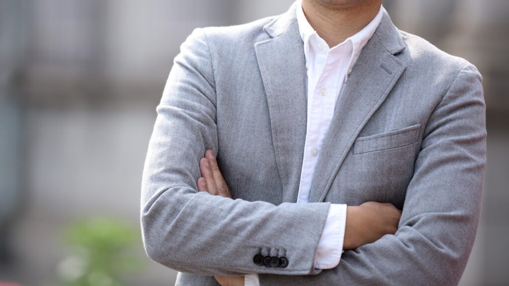 グレーのスーツで腕を組む男性