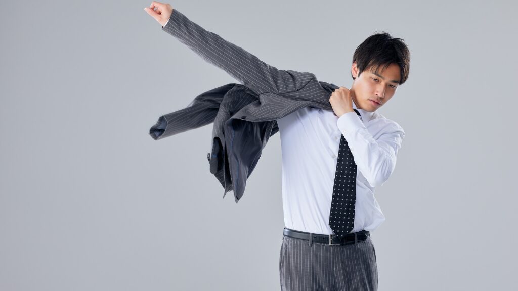 男性がスーツの上着を羽織る様子